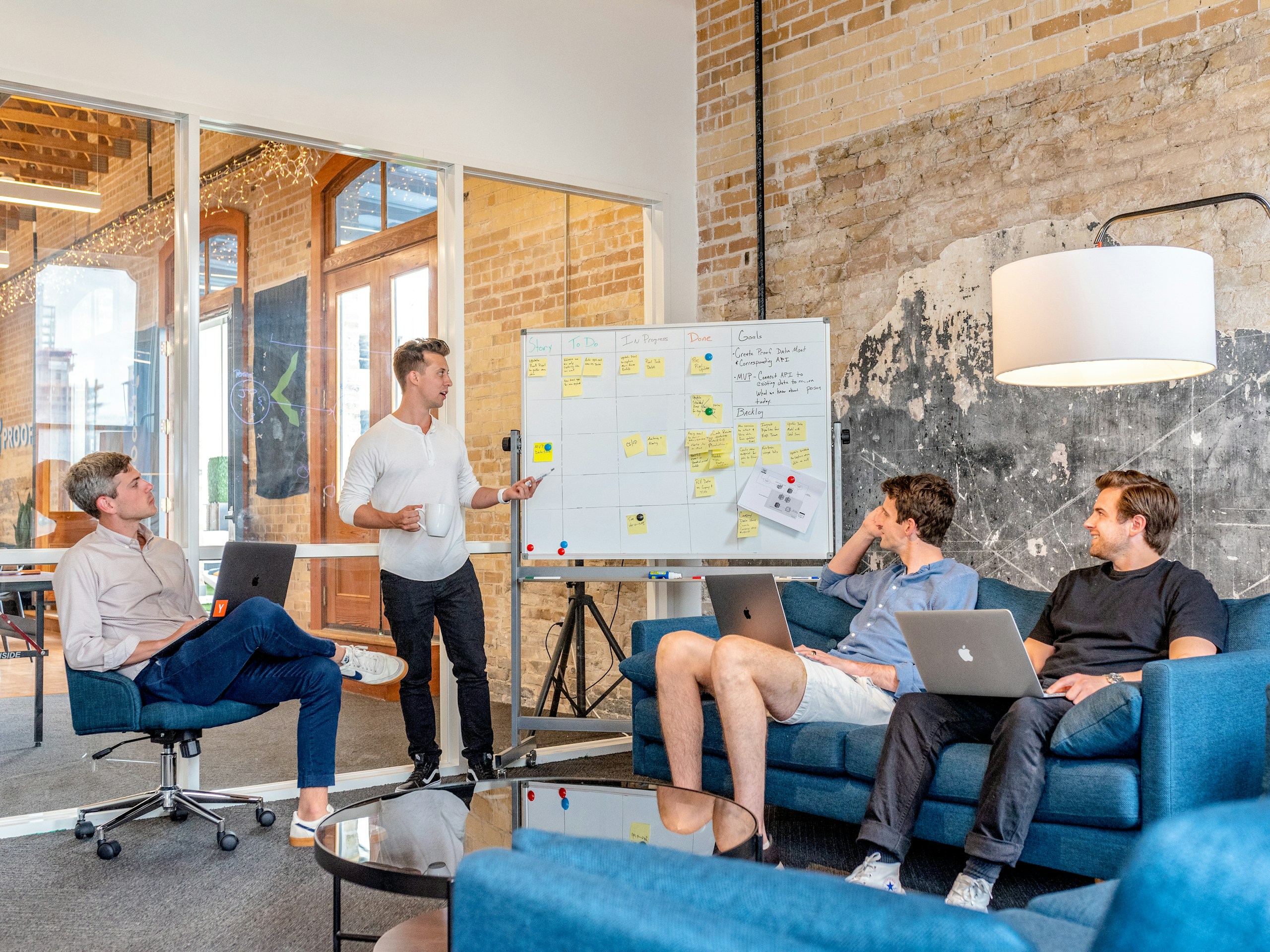 A facilitator guiding three participants through ideas on a planning board