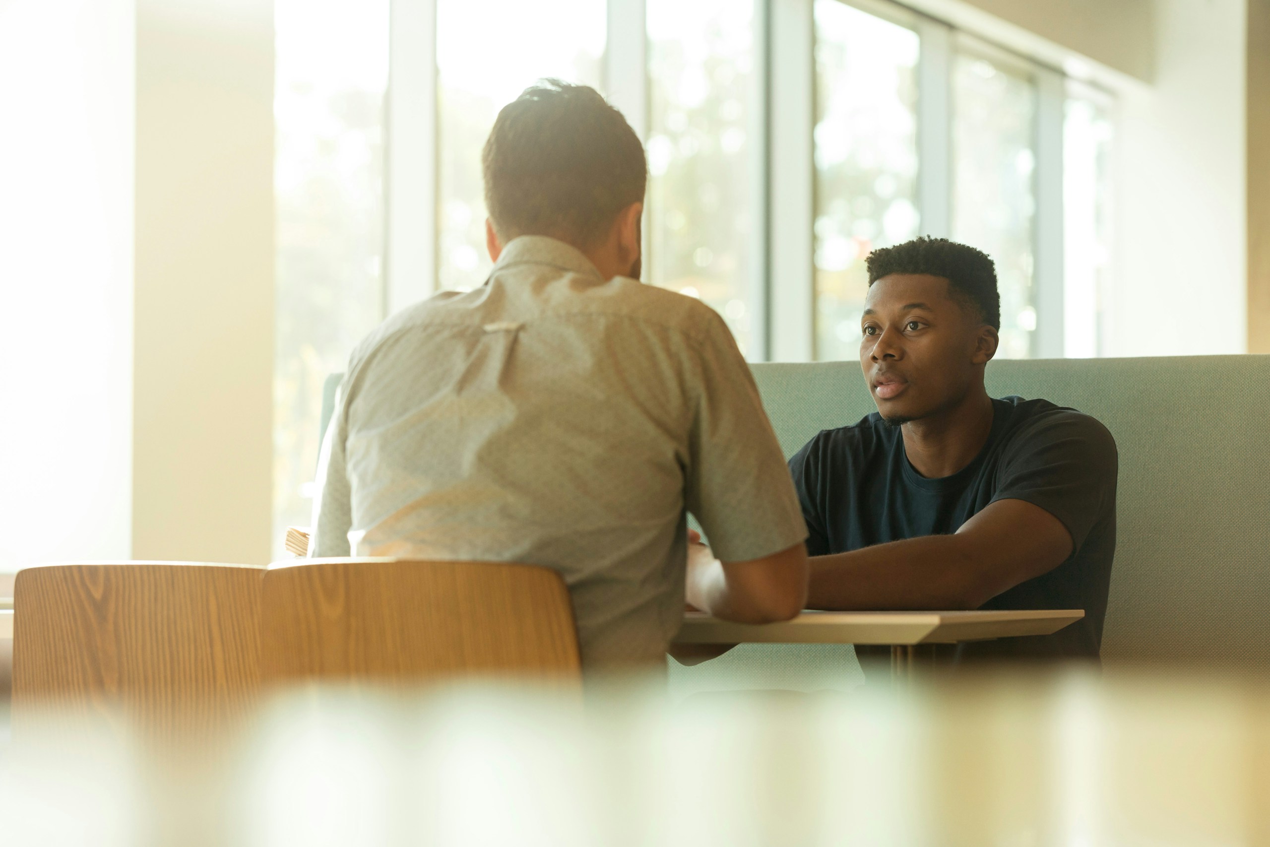 Two people in a focused conversation across a small table